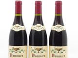 trois bouteilles de vin sont alignées sur une surface blanche