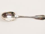 a spoon that is sitting on a white surface