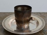une tasse et une soucoupe en argent posées sur un plateau en argent