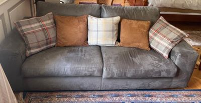 un canapé avec des coussins et un tapis posé à même le sol