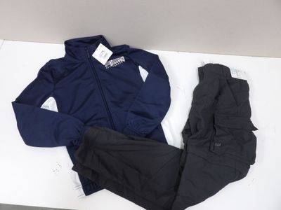 un survêtement et un pantalon bleu marine et noir posés sur une table blanche