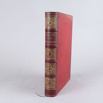un vieux livre rouge posé sur une surface blanche