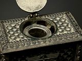 a small metal box with a coin on top of it