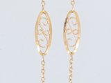 a gold necklace with a spiral design hanging from it ' s chain