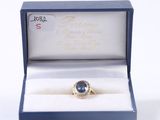 a ring in a box with a blue stone in it