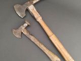 two old axes sitting on top of a table next to each other