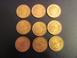 six types différents de pièces d'or sur une surface noire