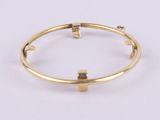 a close up of a gold bang bracelet with a square clasp