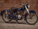 a blue motorcycle that is parked in front of a brick wall