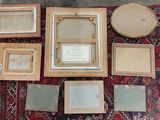 many framed pictures on a rug on the floor