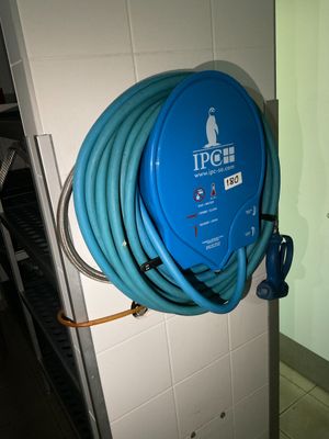 un tuyau bleu fixé au mur d'une salle de bains