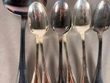 five spoons and two spoons sitting on a table