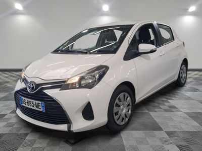 La Toyota Yaris est garée dans une salle blanche au sol à damier.