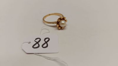 une bague ornée d'une perle et d'une étiquette de prix
