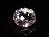 a close up of a pink diamond on a black surface
