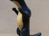 une statue bleue et jaune représentant un lézard, posée sur une surface beige clair