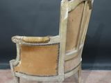 an old chair with a leather seat and a wooden frame