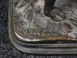a bronze statue of a person on a surfboard in the water