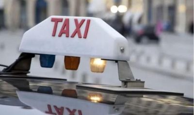 un panneau « taxi » posé sur le toit d'une voiture dans une rue de la ville