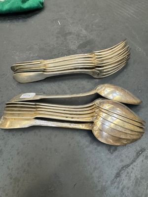 three forks and spoons on a table with a green cloth