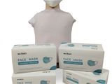 a person wearing a face mask and three boxes of face masks