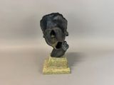 statue of a man with his mouth open on a wooden base