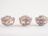 three small vases sitting on top of a white surface next to each other