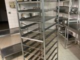 une grande étagère métallique sur laquelle sont posés de nombreux plats