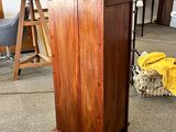 a wooden cabinet in the middle of a room