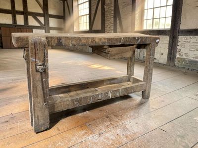 a wooden table with a shelf on it in the middle of a room