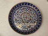 a blue and white plate with flowers on it on a table