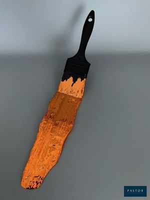 un pinceau orange posé sur une surface grise