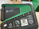 un appareil électronique vert et noir posé sur une table en bois