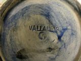 a close up of a blue and white vase with a name on it