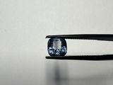 un gros plan sur une paire de pinces tenant un diamant bleu
