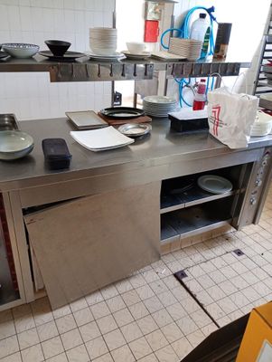 plan de travail en acier inoxydable dans une cuisine professionnelle, sur lequel sont posés des plats