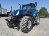 un tracteur bleu garé sur un parking à côté d'un camion