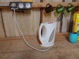 a kettle that is sitting on a shelf next to a cup