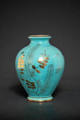 a blue vase with a gold leaf design on it