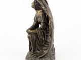 an image of a statue of a woman sitting on a rock