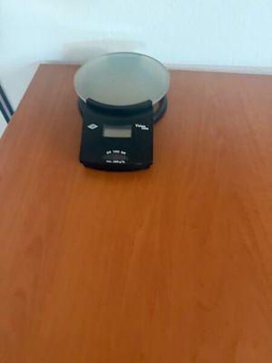 a scale sitting on a wooden table in front of a white wall