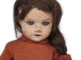 doll with brown hair and blue eyes wearing a brown sweater