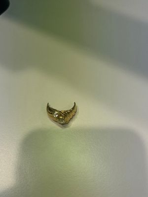 un petit morceau d'or posé sur une surface blanche