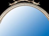 a mirror that is sitting on the wall with a blue sky in the background