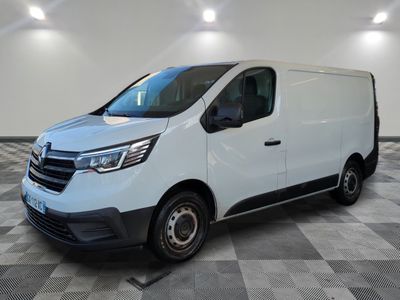 Une camionnette blanche est garée dans une pièce au sol carrelé en damier.