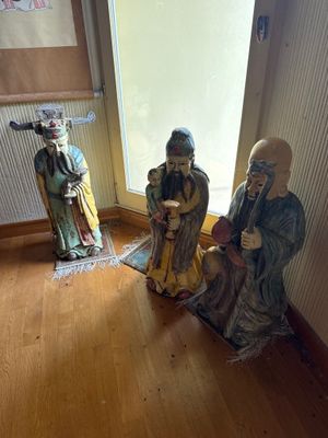 trois figurines assises dans un coin d'une pièce