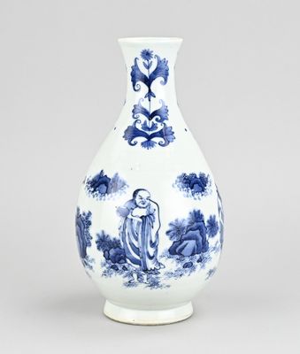 vase en porcelaine bleue et blanche orné de personnages et de fleurs, posé sur un socle