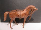 a wooden horse with a saddle on it ' s back