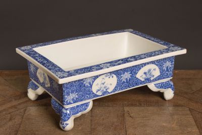 un petit bol bleu et blanc posé sur une table en bois