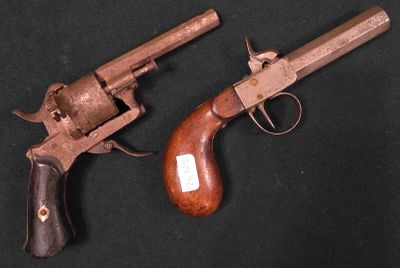 deux vieux revolvers sur fond noir, avec une crosse en bois